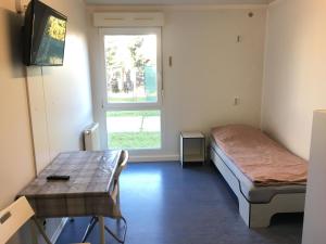 a room with a bed and a table and a window at Hostel Września in Września
