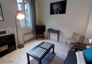 uma sala de estar com um sofá e uma mesa em Le petit cauchois em Rouen