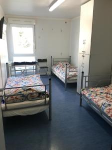 a room with three bunk beds and a window at Hostel Września in Września
