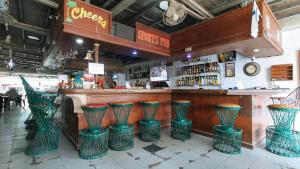 um bar com bancos verdes num restaurante em RedDoorz Plus Lagoon Resort Zambales em Olongapo
