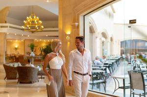 Un uomo e una donna in piedi davanti a un ristorante di Three Corners Fayrouz Plaza Beach Resort a Port Ghalib