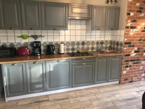 kuchnia z szarymi szafkami i ceglaną ścianą w obiekcie Ferienwohnung Anna Swinemünde Rycerska w Świnoujściu +17 zdjęć