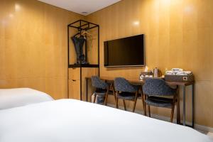 a hotel room with a bed and a desk and a tv at Hotel The Designers Kondae in Seoul