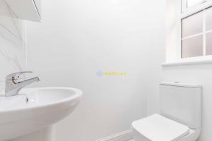 a white bathroom with a sink and a toilet at 2 BED Modern apartment. Close to station & PARKING in Slough