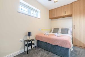 a small bedroom with a bed and a window at 2 BED Modern apartment. Close to station & PARKING in Slough