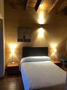 a bedroom with a large bed and two lamps at Casa Rural Fuente la Bolera in Gilbuena