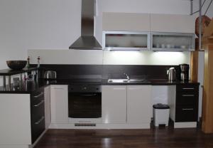 a kitchen with white cabinets and a stove and a sink at Private holiday house Vivendi in Liptovský Mikuláš
