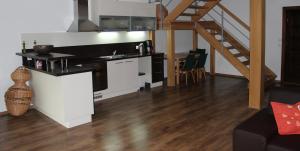 a kitchen with white cabinets and a staircase in a room at Private holiday house Vivendi in Liptovský Mikuláš