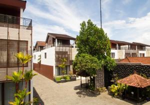 a courtyard of a building with trees and buildings at Kuta Ardenia Residence in Kuta