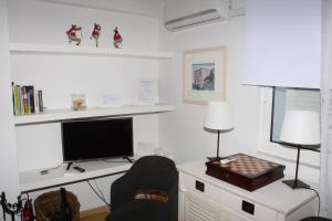 a living room with a television and a desk with a chessboard at Kalavrita Luxurious Apartments in Kalavrita