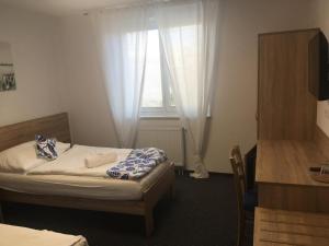 ein kleines Schlafzimmer mit einem Bett und einem Fenster in der Unterkunft MOTOREST-PENSION U HRACHŮ,s.r.o. in Klatovy