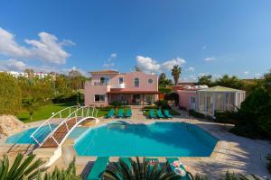 een huis met een zwembad en een huis bij Villa Coral Bay View, walking distance to the beach! in Peyia