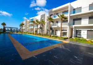 an empty swimming pool in front of a building at Charmant Appartement avec une vue imprenable in Tamaris
