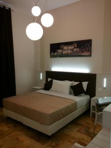 a bedroom with a bed and two pendant lights at Manila Inn in Rome