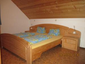 a wooden bed with blue pillows in a bedroom at Ferienwohnung A 55 m2 in Lachtal
