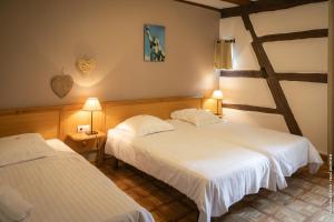 a hotel room with two beds and two lamps at Hôtel le Saint Nicolas in Riquewihr
