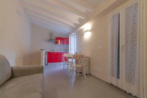 sala de estar con sofá y cocina con armarios rojos. en Carruggio, en Riomaggiore