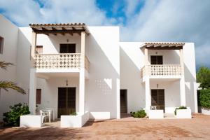 two views of a white house with a balcony at Apartamentos Escandell - Formentera Vacaciones in Playa Migjorn