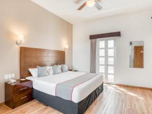 a bedroom with a bed and a dresser at Hotel Quinta Allende in Querétaro