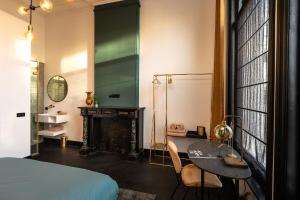 a bedroom with a bed and a table and a fireplace at Stella Suites Boutique Hotel in Goirle