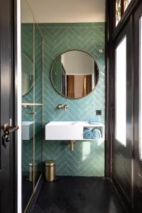 a bathroom with a sink and a mirror at Stella Suites Boutique Hotel in Goirle