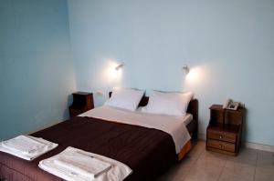 a bedroom with a large bed with two night stands at APRAOS BAY HOTEL in Apraos