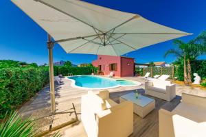 duży biały parasol i krzesła oraz basen w obiekcie Luxury Villas w mieście Lascari