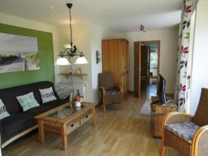 a living room with a couch and a table at Margarethenhof in Tetenbüll +15 photos
