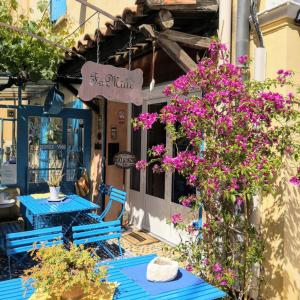 twee blauwe tafels met paarse bloemen op een patio bij Fa Mille Maison Bleue in Robion en Luberon