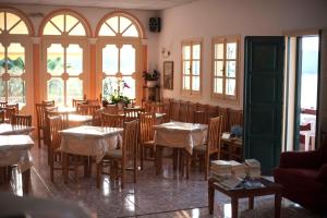 a dining room with tables and chairs and windows at APRAOS BAY HOTEL in Apraos