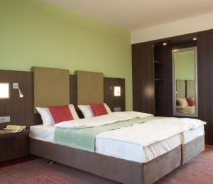 a bedroom with a large bed in a room at Qualitel Wilnsdorf in Wilnsdorf +23 photos