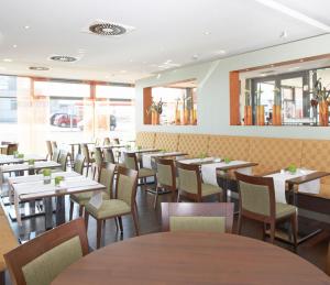 a dining room filled with tables and chairs at Qualitel Wilnsdorf in Wilnsdorf