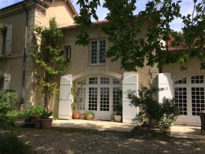 una casa con puertas blancas y un patio en Domaine Fontaine, en Visan