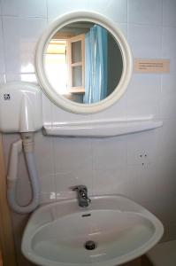 La salle de bains est pourvue d'un lavabo et d'un miroir. dans l'établissement APRAOS BAY HOTEL, à Apraos