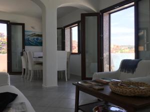 a living room with a table and chairs and windows at Casa Castel in Castelsardo