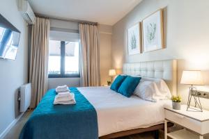 マドリードにあるSalamanca Luxuryのベッドルーム(青色をアクセントにした白い大型ベッド1台付)