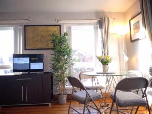 een woonkamer met een tafel en stoelen en een televisie bij Central City - Parking - Great Location -4 Beds in Belfast