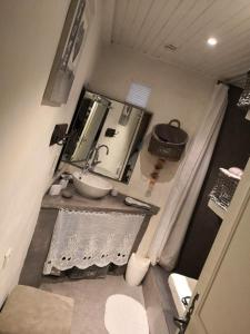 a small bathroom with a sink and a mirror at Fa Mille Maison Bleue in Robion en Luberon