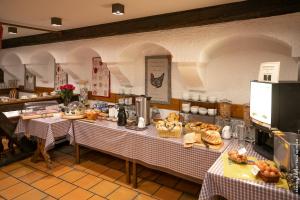 un restaurante con dos mesas con platos de comida en Hôtel le Saint Nicolas en Riquewihr