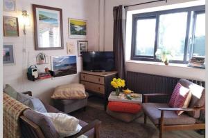 sala de estar con sofá y TV en Cattle Shed Cottage, en Narberth