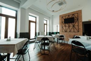 a room with tables and chairs and a brick wall at Roa Guesthouse in Blaj