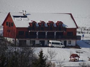 a large house with snow on top of it at Rejtek Vendégház in Lispeszentadorján