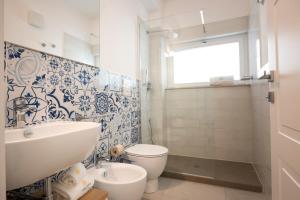 bagno con servizi igienici bianchi e lavandino di Candiano Palace a Portopalo