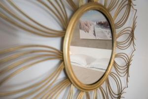 uno specchio che riflette un letto in una stanza di Candiano Palace a Portopalo