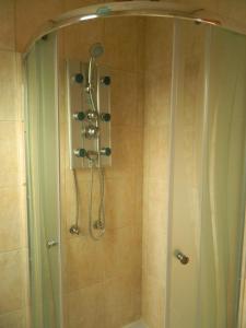 y baño con ducha con cabezal de ducha. en Hostal Parediso, en Punta Arenas