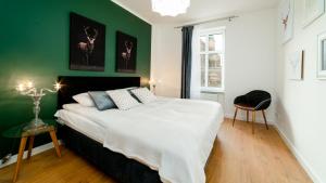 - une chambre avec un grand lit et un mur vert dans l'établissement Apartamenty EverySky - Górna 8, à Jelenia Góra