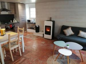 a living room with a couch and a stove at Charmante petite maison de la côte Normande in Courseulles-sur-Mer