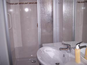 a white bathroom with a sink and a shower at Ferienhaus am Kaltenstein in Olbersdorf