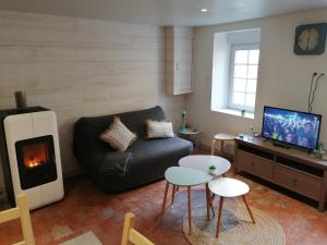 sala de estar con sofá y chimenea en Charmante petite maison de la côte Normande, en Courseulles-sur-Mer