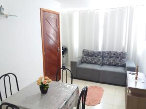 sala de estar con mesa y sofá en Flat Maragogi 3, en Maragogi